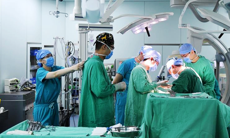 男護士郭岳斌（左二）在手術室裡配合醫生手術

