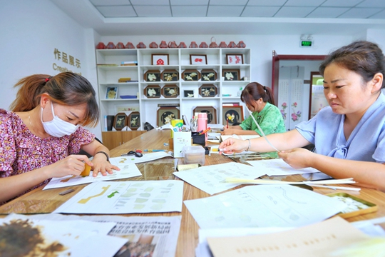 在郑州市上街区颐苑社区，社区居民在制作麦秆画。