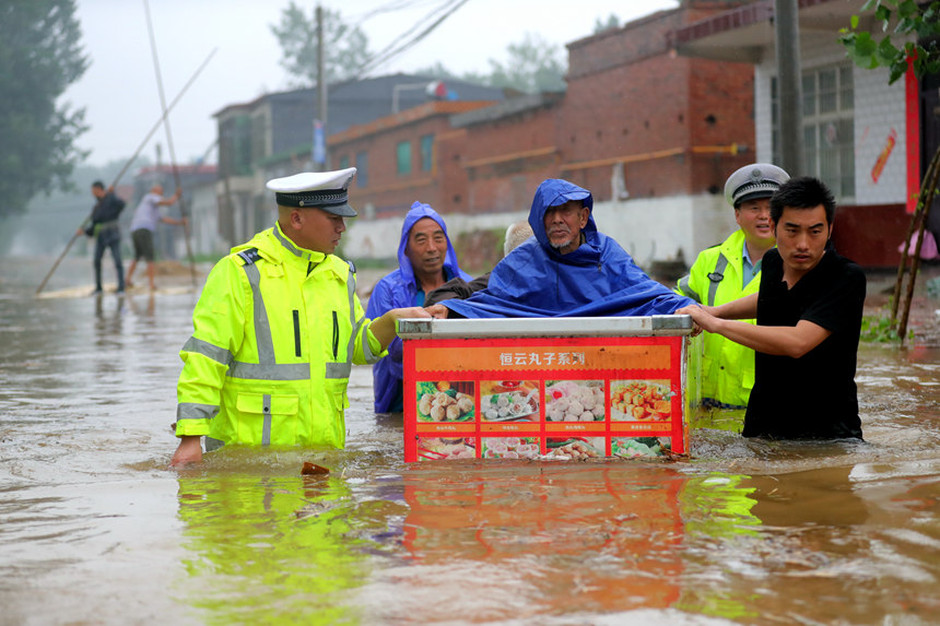 7月22日，河南省公安厅高速交警总队民警在新乡卫辉黄庄暴雨严重地区救助被困群众。杨军政摄 