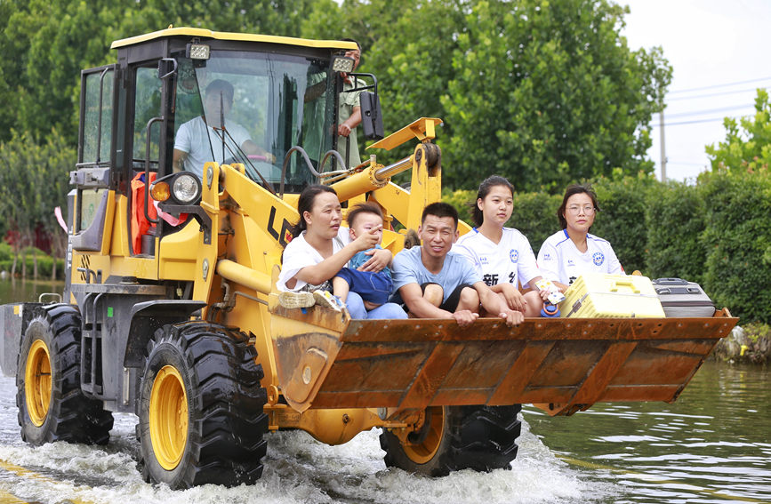 7月28日，新乡市北环路附近积水较深，救援人员用铲车搭载群众。人民网 霍亚平摄