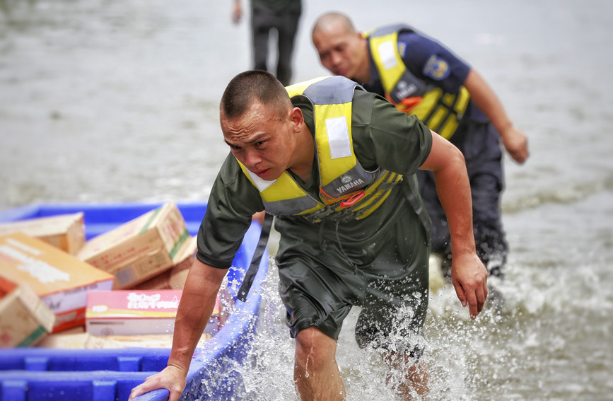 7月28日，新乡市北环路附近积水较深，救援人员转运救灾物资。人民网 霍亚平摄
