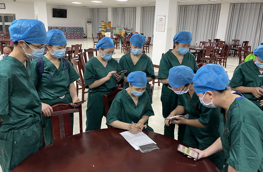 检测人员进行分工，对下一步工作展开讨论。河南省肿瘤医院供图