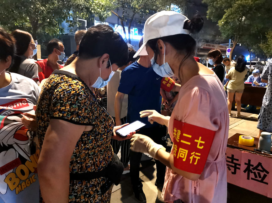 志愿者帮助市民扫码预约。郑州市淮河路街道办供图