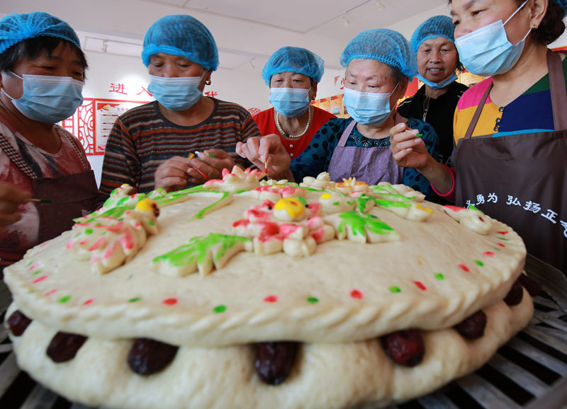 函丈村民间艺人给传统面食“枣糕馍”上色。