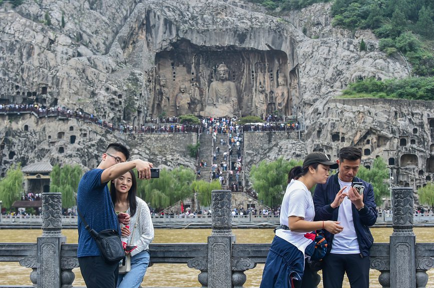 近日，游客在參觀游覽世界文化遺產洛陽龍門石窟，感受千年石窟文化，享受休閑假期。黃政偉攝