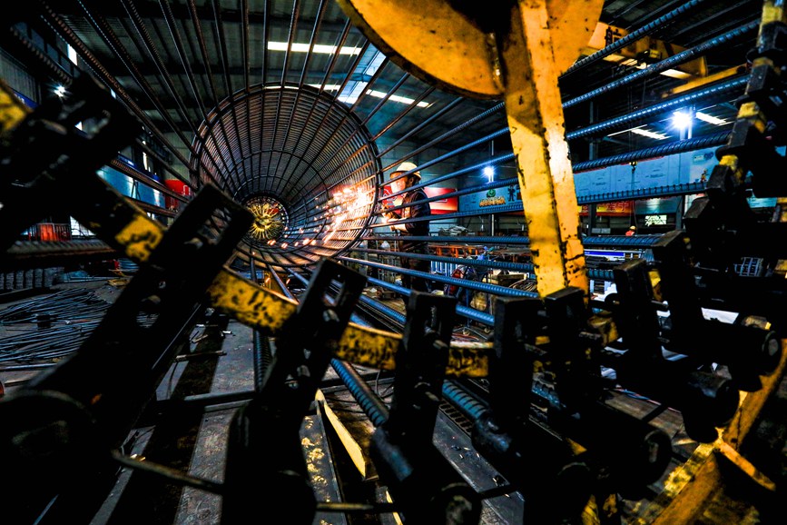 4月30日，在栾卢高速中交三航局六标钢筋加工厂，工人在桩基钢筋笼焊接设备上精心焊接长达30米的钢筋笼。聂金锋