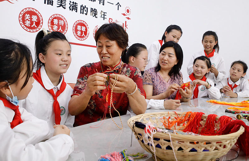 6月2日，河南省开封市尉氏县实验小学师生和独居老人一起包粽子、缝香包，感受传统节日文化魅力。李新义摄 