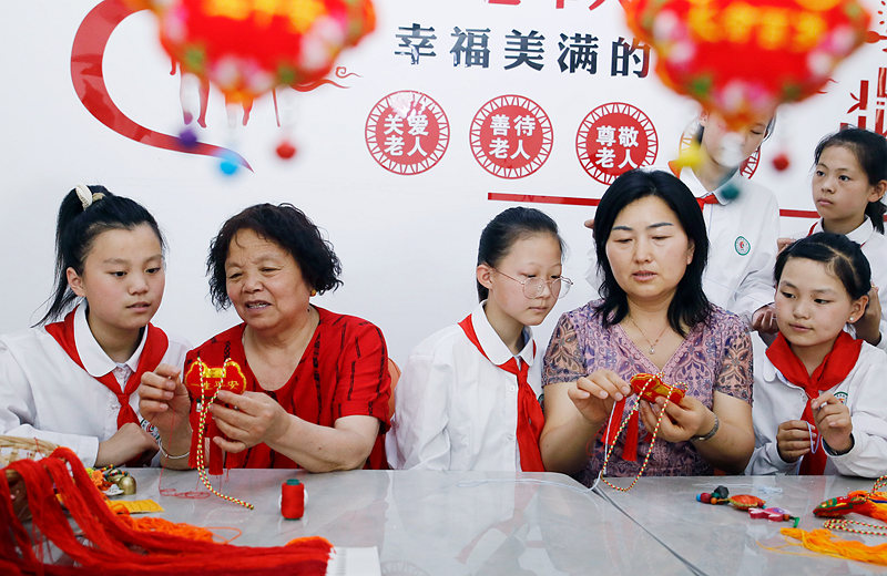 6月2日，河南省开封市尉氏县实验小学师生和独居老人一起包粽子、缝香包，感受传统节日文化魅力。李新义摄 