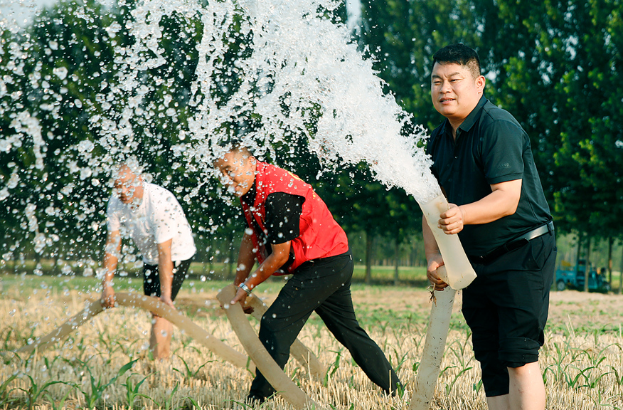 河南尉氏县邢庄乡的党员志愿者在尹庄村帮助缺少劳力的农户浇灌玉米苗。  李新义摄