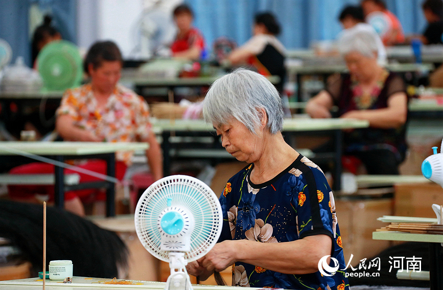 河南叶县水寨乡桃奉村假发厂生产车间，村民在手工制作假发。人民网 霍亚平摄