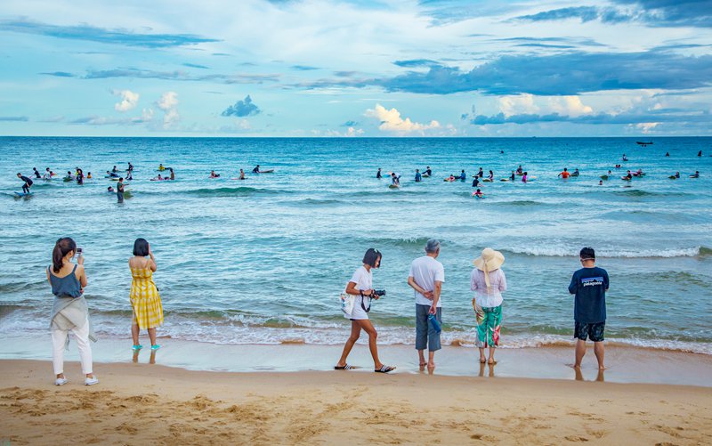 万宁日月湾，前来体验冲浪的游人如织。万宁市旅文局供图