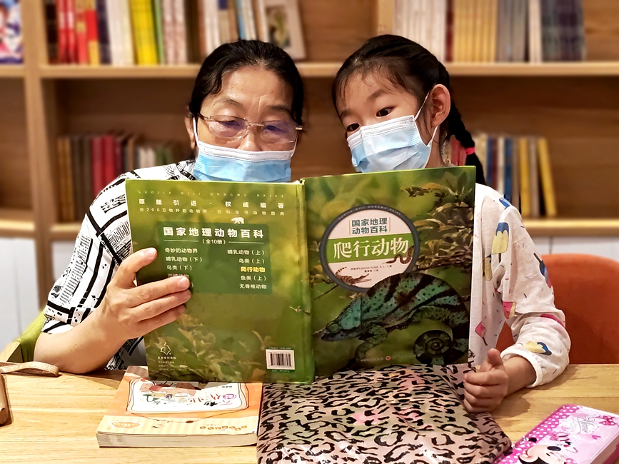 在南阳市宛城区一处“诸葛书屋”，家长正陪同孩子一起阅读。史源远摄
