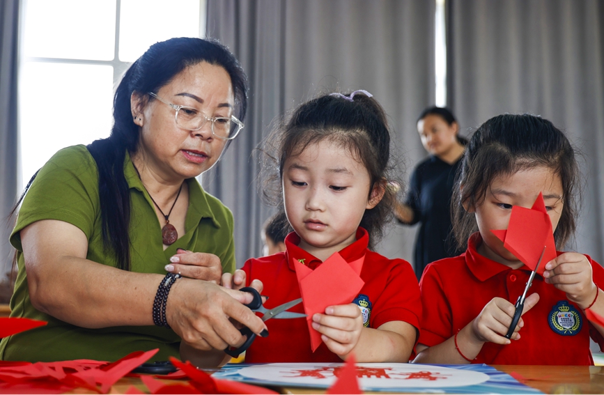 剪纸传承人樊晓磊和孩子们一起剪纸。尹明晓摄