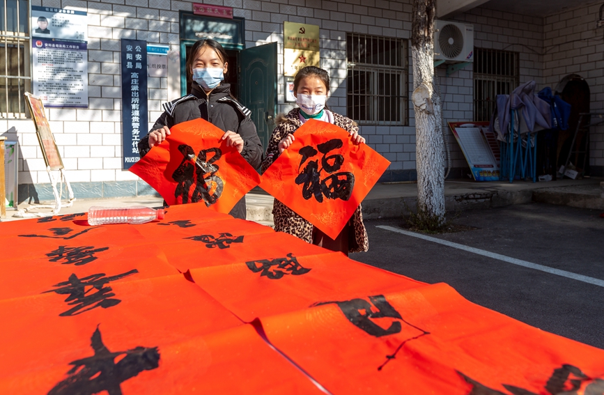 小朋友手拿大红“福”字，喜笑颜开。王建安摄