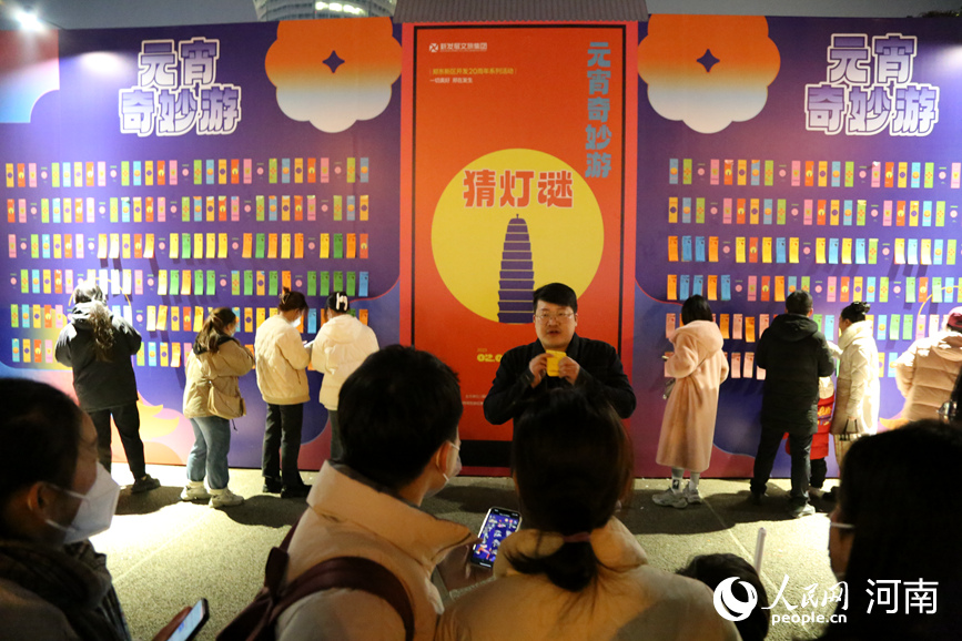 众人对猜灯谜活动产生浓厚兴趣。人民网 于思远摄