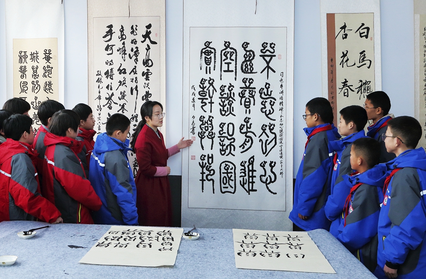 同学们聚精会神地听老师讲解甲骨文的历史意义。牛文堂摄