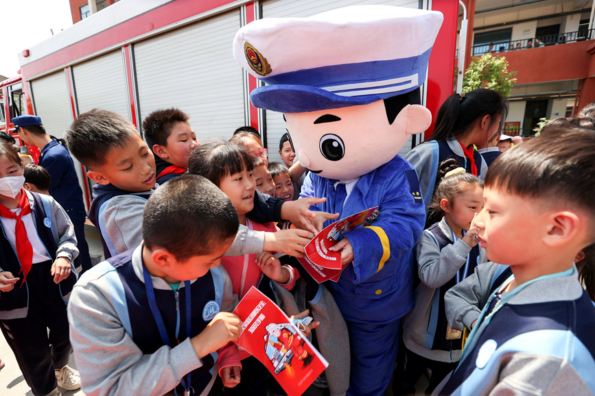 5月8日，河南省濟源市消防救援支隊宣傳人員向孩子們發放宣傳材料。張步高攝