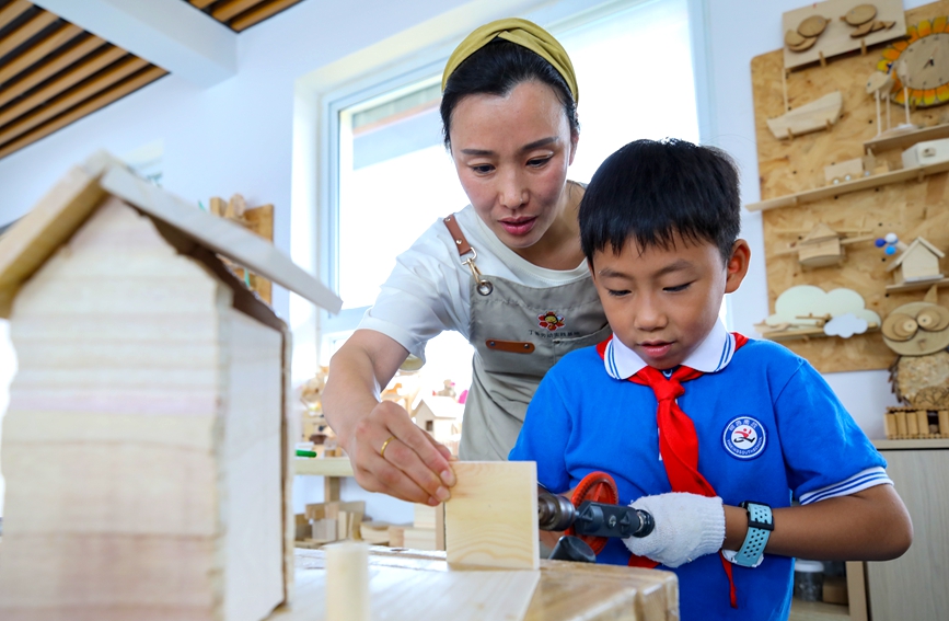 7月13日，安阳市高新区银杏南校“给小鸟安个家”暑期延时服务课，学生正在制作鸟屋。麻翛然摄 