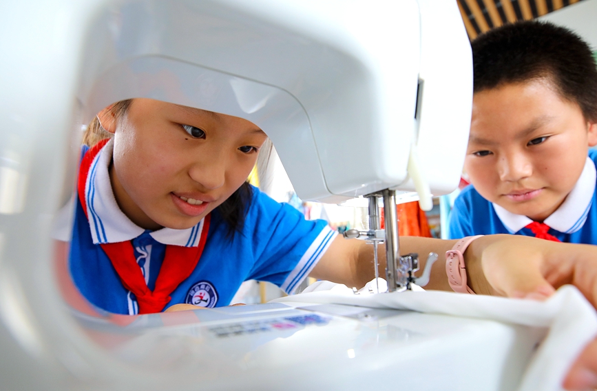 7月13日，安阳市高新区银杏南校汉服设计暑期延时服务课，学生动手缝制汉服。麻翛然摄