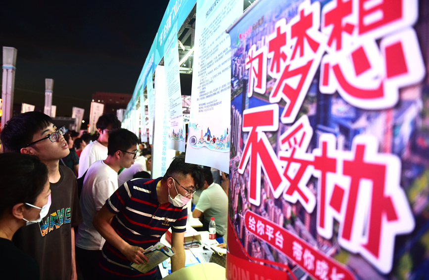 求职者在河南洛阳2023年“职”在河南—制造业民营企业专场夜市招聘活动上咨询招聘信息。 黄政伟摄