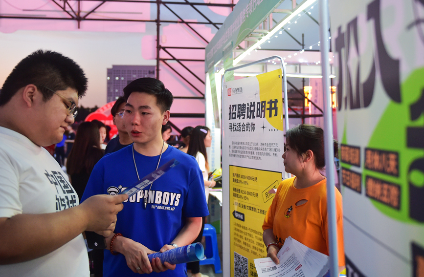 求职者在河南洛阳2023年“职”在河南—制造业民营企业专场夜市招聘活动上咨询招聘信息。黄政伟摄