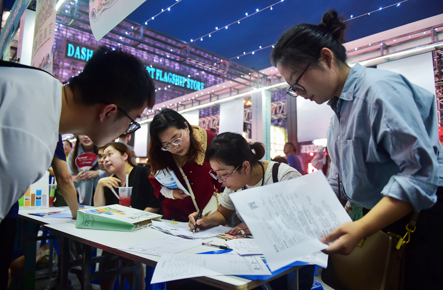 求职者在河南洛阳2023年“职”在河南—制造业民营企业专场夜市招聘活动上咨询招聘信息。黄政伟摄