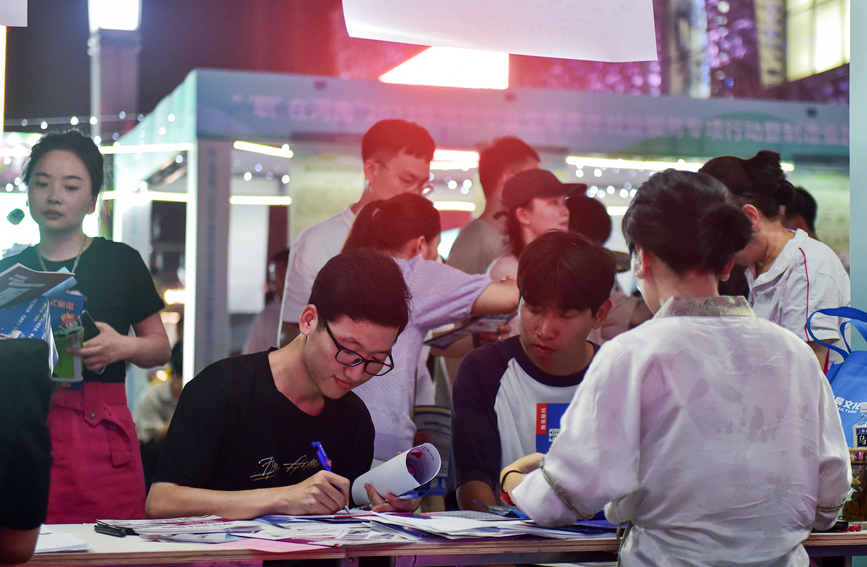 求职者在河南洛阳2023年“职”在河南—制造业民营企业专场夜市招聘活动上填写信息。黄政伟摄