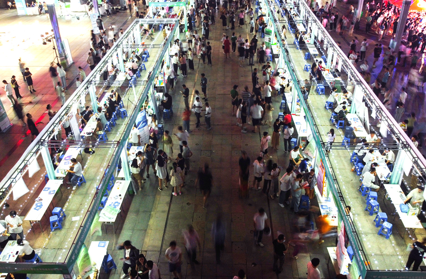 求职者在河南洛阳2023年“职”在河南—制造业民营企业专场夜市招聘活动上咨询招聘信息。黄政伟摄