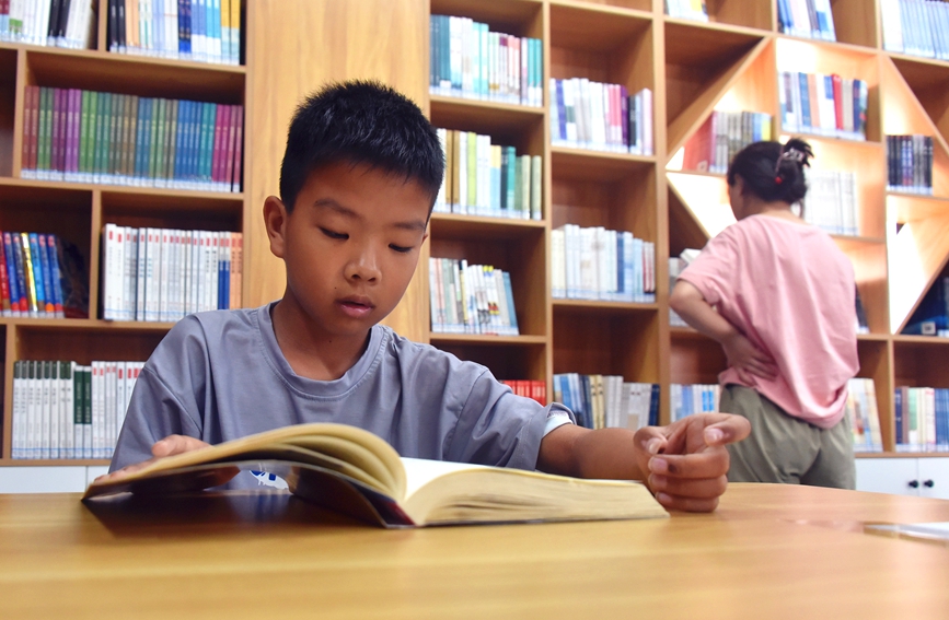 河南省社旗县红旗西路的城市书房——诸葛书屋里，一名小学生正在阅读书籍。申鸿皓摄