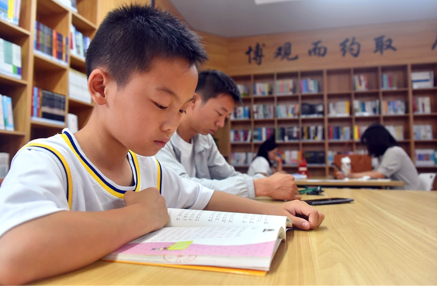 河南省社旗县红旗西路的城市书房——诸葛书屋里，一名小学生正在阅读书籍。申鸿皓摄