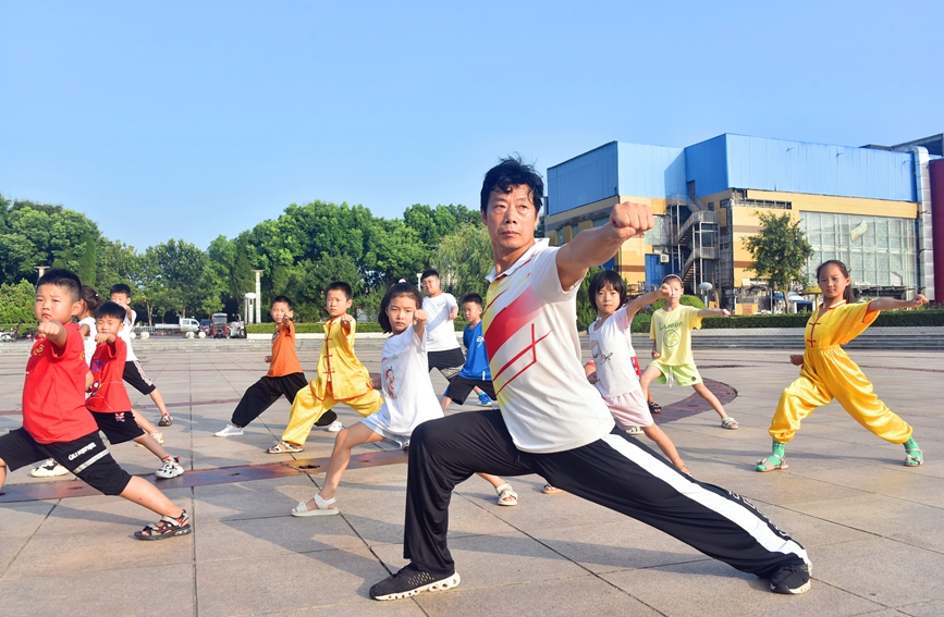 在河南省社旗县新天地广场，小朋友们正在教练指导下学练武术。申鸿皓摄 