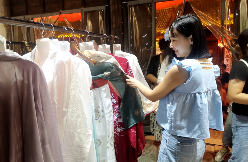 游客在挑选服装。刘斐摄