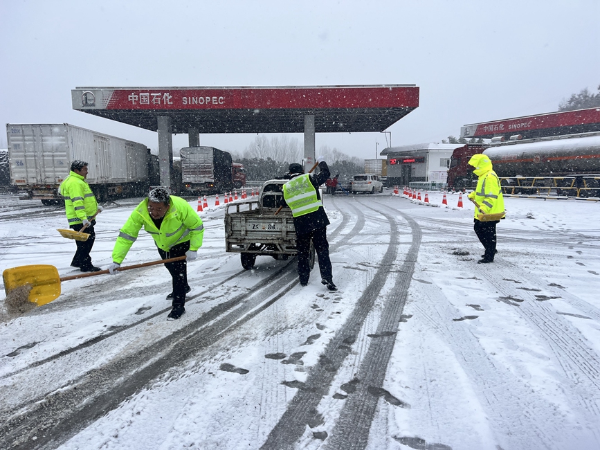 西峽服務區組織員工清理廣場積雪、撒融雪劑，做好除雪保通工作。白小麗 攝