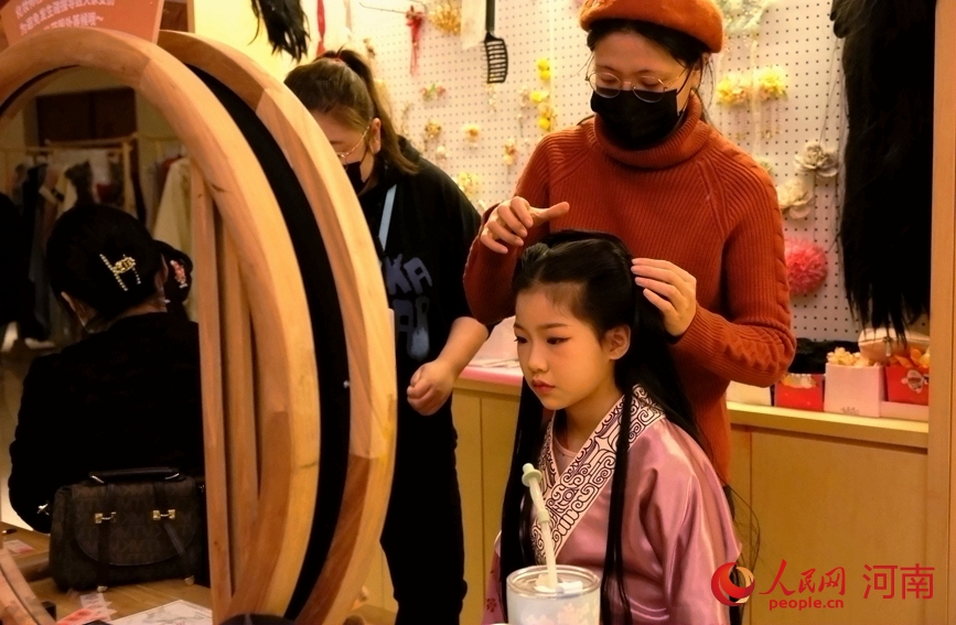 “华服来潮”活动区，小姑娘正在做汉服妆造。人民网 常力元摄