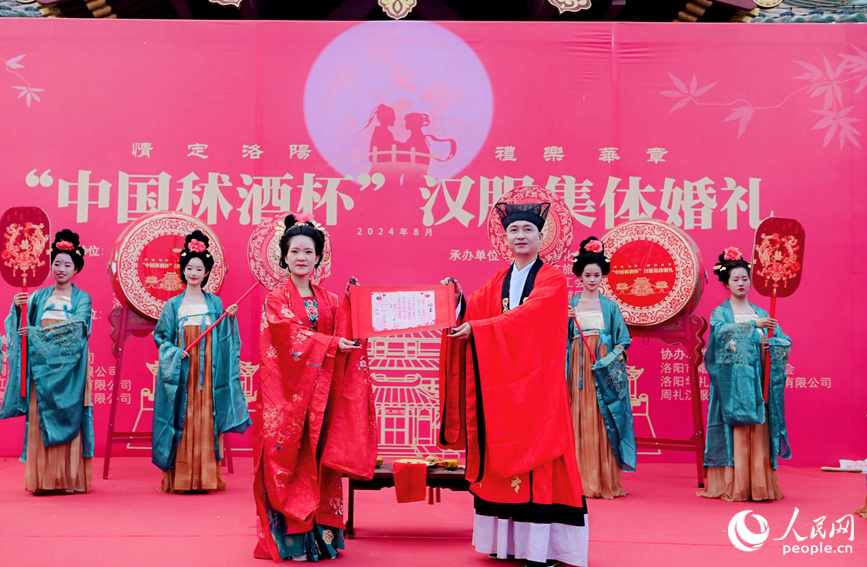 穿上汉服的新人展示婚书。人民网 于思远摄 