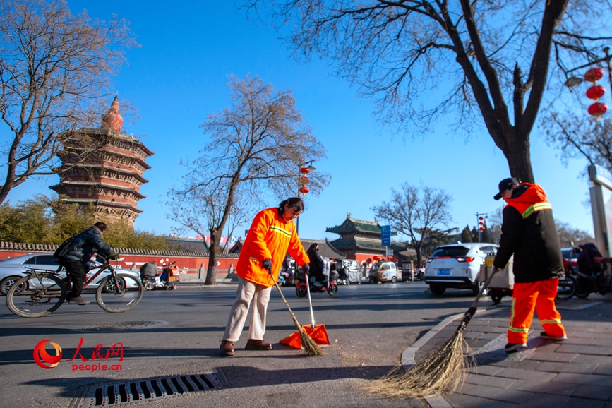 1月29日，安阳市环卫工刘仙芬与同事师秋红在文峰中路清扫人行道。人民网 辛静摄