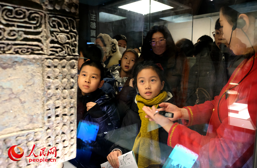 孩子们围在文物展柜前，认真听讲解。人民网 常力元摄