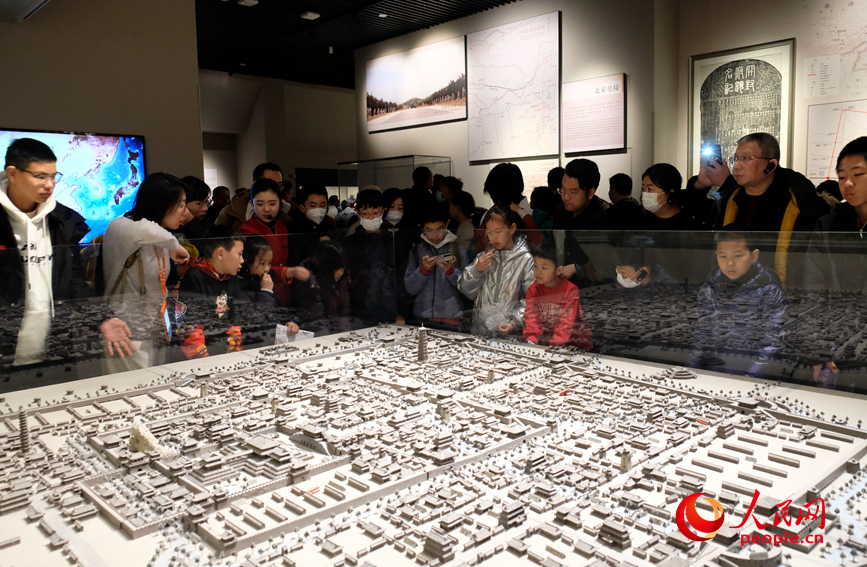 孩子们围在文物展柜前，认真听讲解。人民网 常力元摄