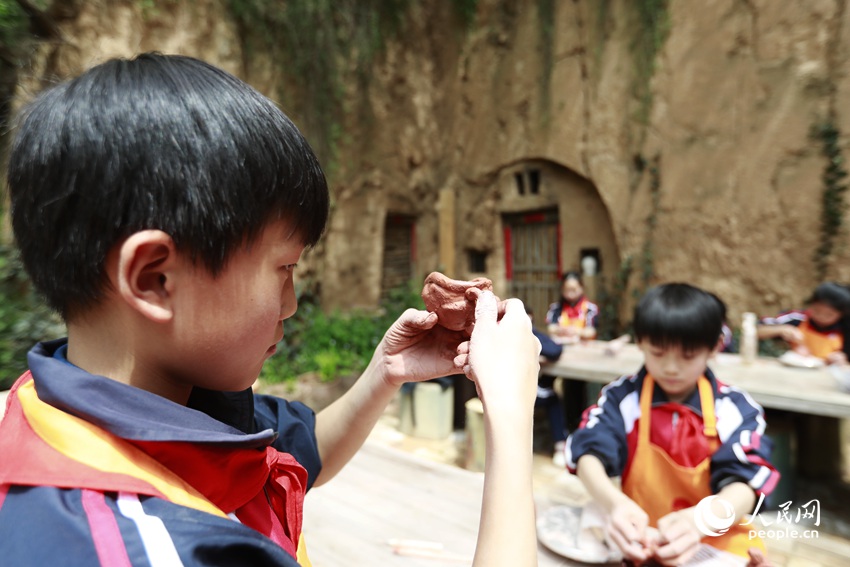 孩子們通過拍、搓、揉、捍、點等手法，感受泥塊在手中的快樂。人民網記者 慎志遠攝 