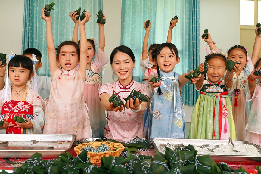 5月28日，河南省南阳市社旗县第三幼儿园举办“双节同庆 童心‘粽’在”亲自游园活动，孩子们在展示包好的粽子。申鸿皓摄