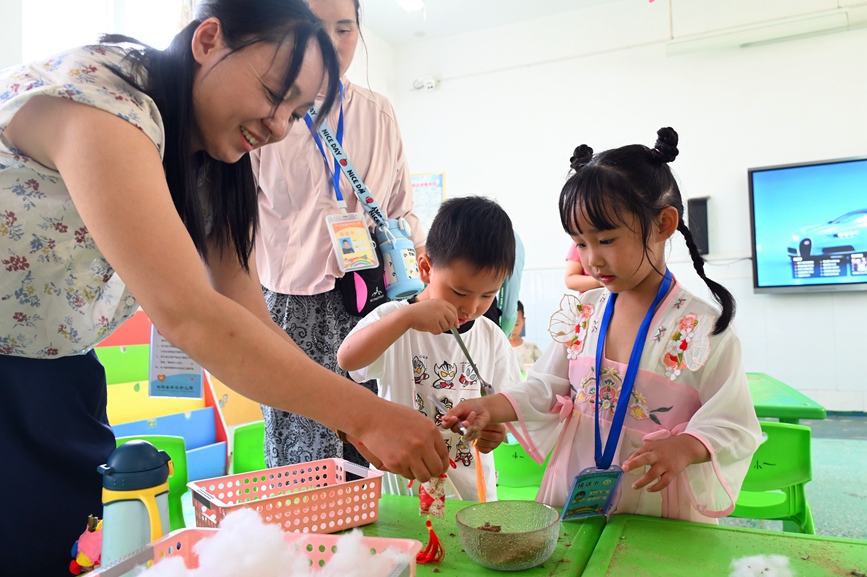5月28日，河南省南阳市社旗县第三幼儿园举办“双节同庆 童心‘粽’在”亲自游园活动，家长和孩子们在制作香囊。申鸿皓摄