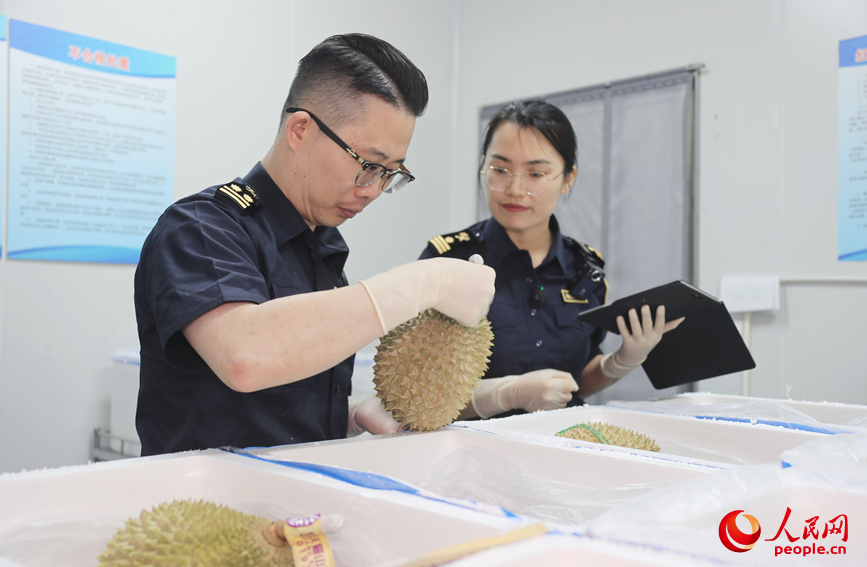 海关工作人员对货物进行查验。人民网 霍亚平摄