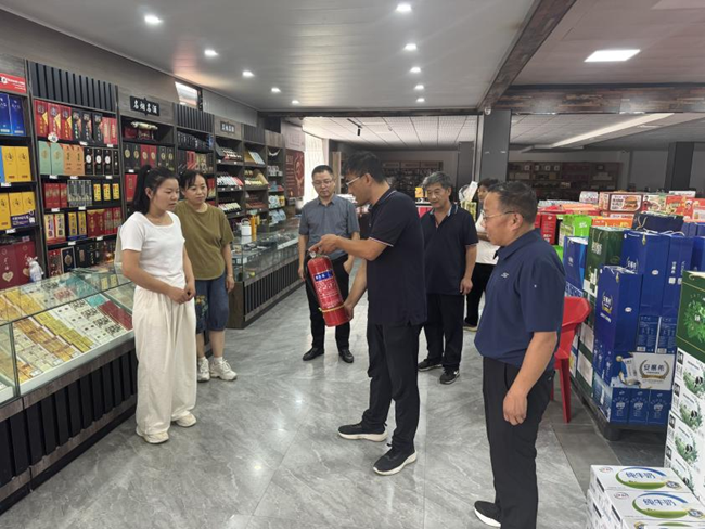 图为许昌市烟草公司鄢陵县分公司安全宣传员向零售客户讲解消防设施使用知识。