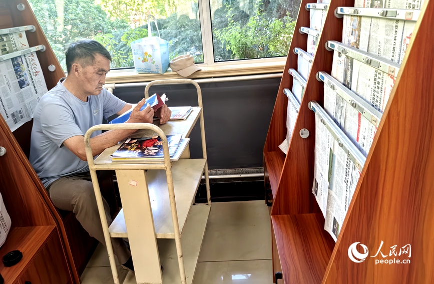 河南省图书馆嵩山路馆中文报纸阅览室里，一位老人在看杂志。人民网 辛静摄