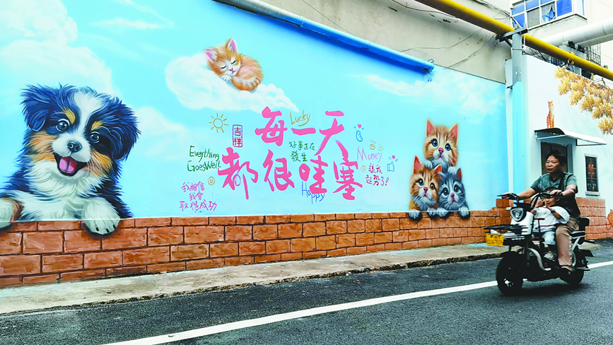 行人从平高巷彩绘墙边驶过 王孟鹤 摄
