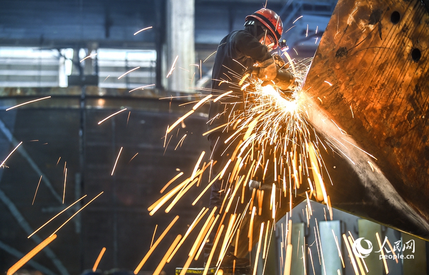 河南省洛阳市的中信重工铆焊车间内，工人正在加工打磨处理一批出口的矿用磨机产品订单。人民网记者 尚明桢摄