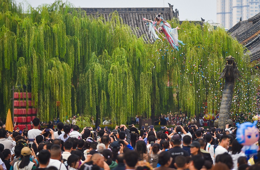 国庆中秋假期，游客在河南洛阳老城区历史文化街区洛邑古城欣赏“天女散花”文艺表演。黄政伟摄