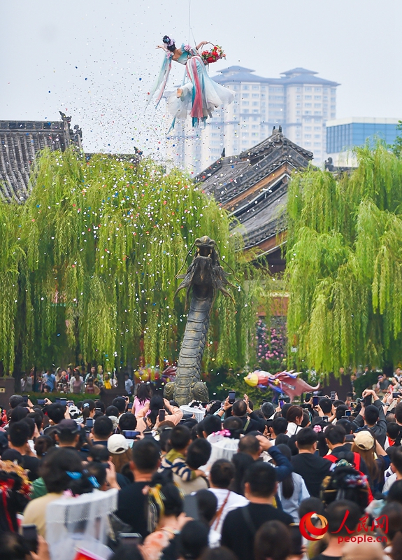 国庆中秋假期，游客在河南洛阳老城区历史文化街区洛邑古城欣赏“天女散花”文艺表演。人民网记者 尚明桢摄