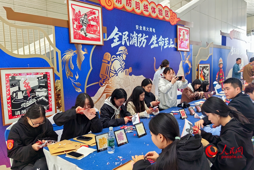 消防剪纸体验区学剪安全提示。人民网 程明辉摄