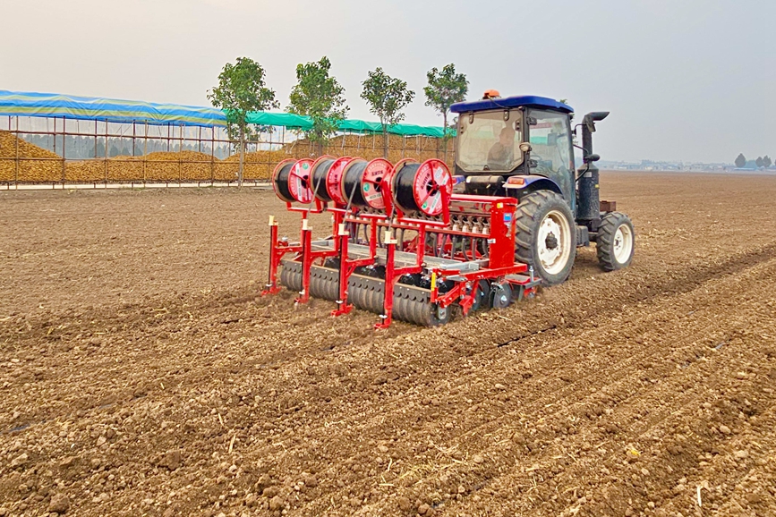 新乡市获嘉县位庄乡大位庄村弘昌家庭农场正在进行小麦导航播种同步铺设滴灌带作业。张哲摄